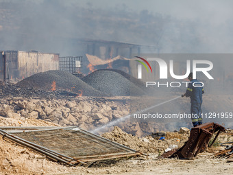 A firefighter is trying to put out the fire in Limassol, Cyprus, on May 31, 2024. Some buildings are in danger after a fire breaks out in th...