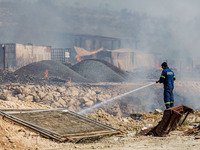 A firefighter is trying to put out the fire in Limassol, Cyprus, on May 31, 2024. Some buildings are in danger after a fire breaks out in th...