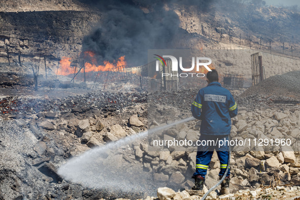 A firefighter is trying to put out the fire in Limassol, Cyprus, on May 31, 2024. Some buildings are in danger after a fire breaks out in th...