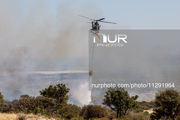 A helicopter is operating during the fire in Limassol, Cyprus, on May 31, 2024. Some buildings are in danger after a fire breaks out in the...