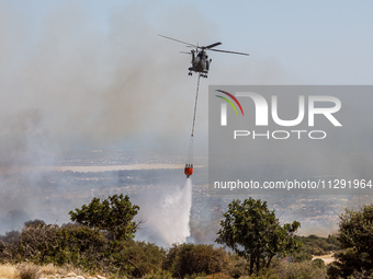 A helicopter is operating during the fire in Limassol, Cyprus, on May 31, 2024. Some buildings are in danger after a fire breaks out in the...