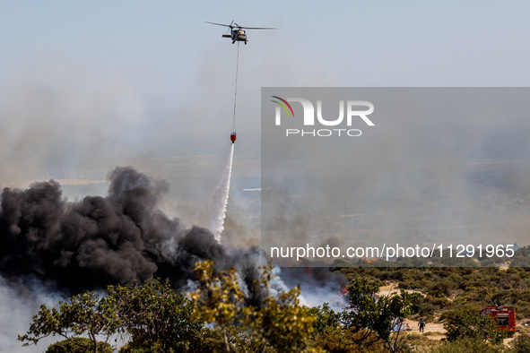 A helicopter is operating during the fire in Limassol, Cyprus, on May 31, 2024. Some buildings are in danger after a fire breaks out in the...