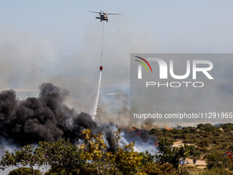 A helicopter is operating during the fire in Limassol, Cyprus, on May 31, 2024. Some buildings are in danger after a fire breaks out in the...