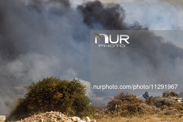 A fireman is trying to put out the flames in Limassol, Cyprus, on May 31, 2024. Some buildings are in danger after a fire breaks out in the...