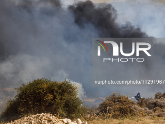 A fireman is trying to put out the flames in Limassol, Cyprus, on May 31, 2024. Some buildings are in danger after a fire breaks out in the...