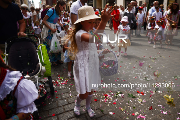 Children scatter flower petals during Corpus Christi procession in Krakow, Poland on May 30, 2024. The procession starts with a priest carry...