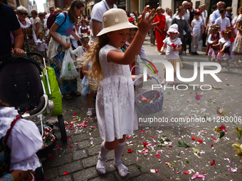 Children scatter flower petals during Corpus Christi procession in Krakow, Poland on May 30, 2024. The procession starts with a priest carry...