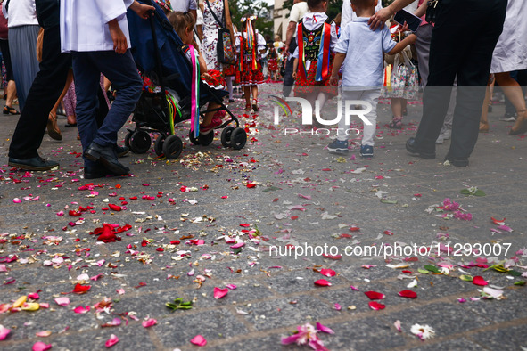 Children scatter flower petals during Corpus Christi procession in Krakow, Poland on May 30, 2024. The procession starts with a priest carry...