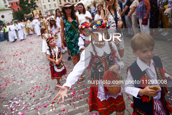 Children scatter flower petals during Corpus Christi procession in Krakow, Poland on May 30, 2024. The procession starts with a priest carry...