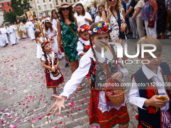 Children scatter flower petals during Corpus Christi procession in Krakow, Poland on May 30, 2024. The procession starts with a priest carry...