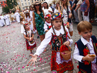 Children scatter flower petals during Corpus Christi procession in Krakow, Poland on May 30, 2024. The procession starts with a priest carry...