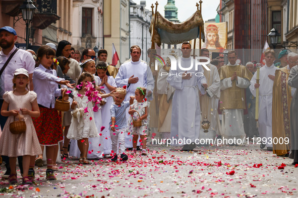 Children scatter flower petals during Corpus Christi procession in Krakow, Poland on May 30, 2024. The procession starts with a priest carry...