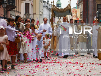 Children scatter flower petals during Corpus Christi procession in Krakow, Poland on May 30, 2024. The procession starts with a priest carry...