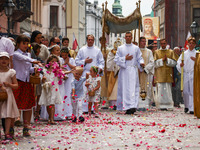 Children scatter flower petals during Corpus Christi procession in Krakow, Poland on May 30, 2024. The procession starts with a priest carry...