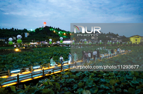 Tourists are visiting the ecological lotus pond in Huaying, China, on May 31, 2024. 