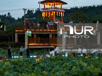 Tourists are visiting the ecological lotus pond in Huaying, China, on May 31, 2024. (