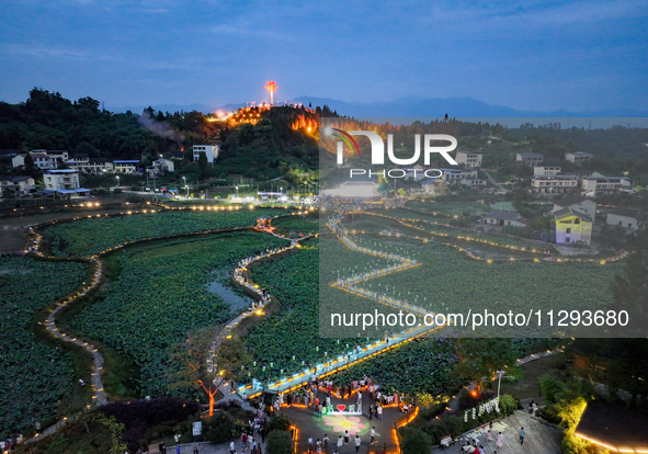 Tourists are visiting the ecological lotus pond in Huaying, China, on May 31, 2024. 