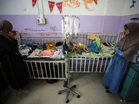 Palestinian women are accompanying children in need of treatment for malnourishment at Al-Aqsa Martyrs Hospital in Deir al-Balah in the cent...