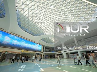 Simulated passengers are passing through the atrium of the T2 terminal of Yantai Penglai International Airport in Yantai, China, on June 1,...