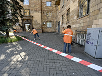 Municipal workers are sweeping away debris outside a residential building after the Russian missile attack in Zaporizhzhia, Ukraine, on June...