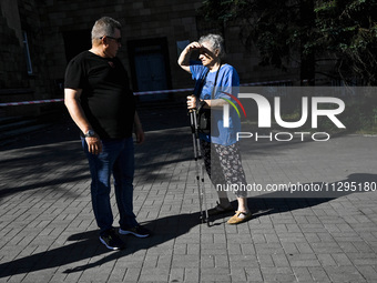 A man and woman are standing in the street after the Russian missile attack in Zaporizhzhia, southeastern Ukraine, on June 1, 2024. In Zapor...