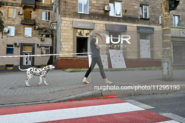 A woman is walking a Dalmatian dog past a residential building after the Russian missile attack in Zaporizhzhia, Ukraine, on June 1, 2024. I...