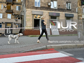 A woman is walking a Dalmatian dog past a residential building after the Russian missile attack in Zaporizhzhia, Ukraine, on June 1, 2024. I...