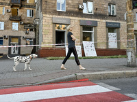 A woman is walking a Dalmatian dog past a residential building after the Russian missile attack in Zaporizhzhia, Ukraine, on June 1, 2024. I...