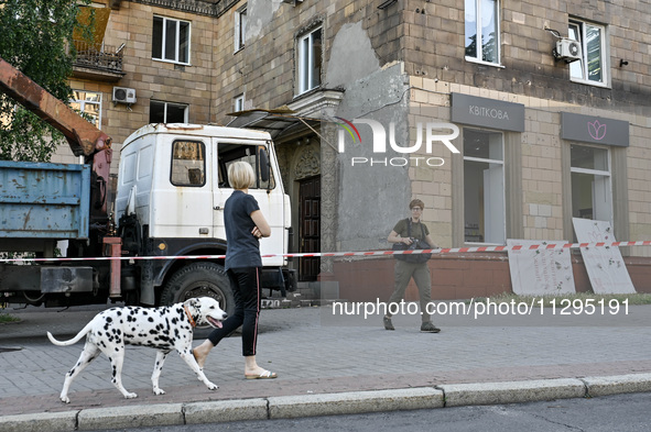 A woman is walking a Dalmatian dog past a residential building after the Russian missile attack in Zaporizhzhia, Ukraine, on June 1, 2024. I...