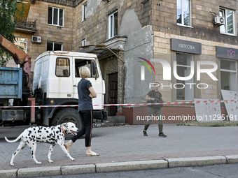 A woman is walking a Dalmatian dog past a residential building after the Russian missile attack in Zaporizhzhia, Ukraine, on June 1, 2024. I...