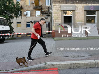 A man is walking a dog past a residential building damaged by the Russian missile attack in Zaporizhzhia, Ukraine, on June 1, 2024. In Zapor...