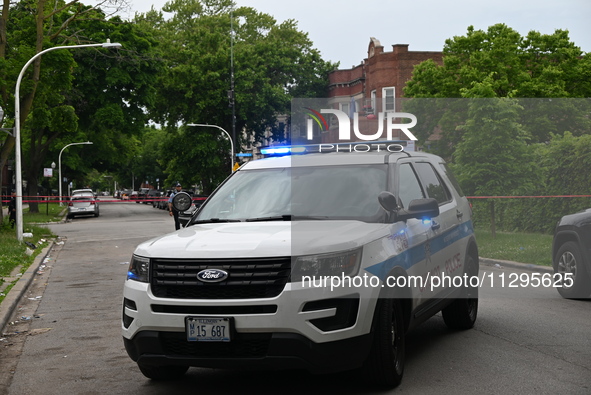 A Chicago police vehicle is blocking the roadway at the crime scene. A 40-year-old male is shot and in critical condition in a shooting in C...