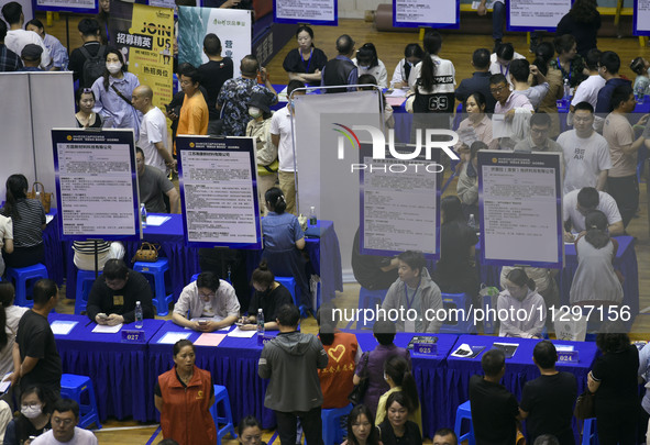 Job seekers are looking for a suitable position at a job fair held by industrial reform enterprises in Huai'an, China, on June 2, 2024. 