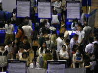 Job seekers are looking for a suitable position at a job fair held by industrial reform enterprises in Huai'an, China, on June 2, 2024. (