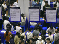 Job seekers are looking for a suitable position at a job fair held by industrial reform enterprises in Huai'an, China, on June 2, 2024. (