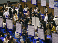 Job seekers are looking for a suitable position at a job fair held by industrial reform enterprises in Huai'an, China, on June 2, 2024. (