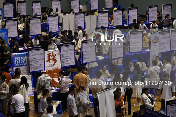 Job seekers are looking for a suitable position at a job fair held by industrial reform enterprises in Huai'an, China, on June 2, 2024. 