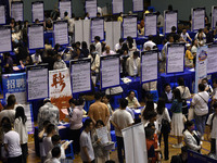 Job seekers are looking for a suitable position at a job fair held by industrial reform enterprises in Huai'an, China, on June 2, 2024. (