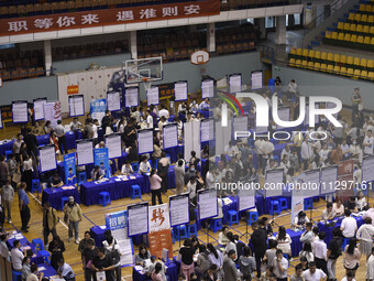 Job seekers are looking for a suitable position at a job fair held by industrial reform enterprises in Huai'an, China, on June 2, 2024. (