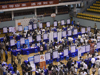 Job seekers are looking for a suitable position at a job fair held by industrial reform enterprises in Huai'an, China, on June 2, 2024. (