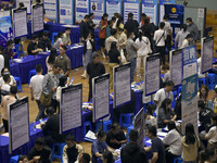 Job seekers are looking for a suitable position at a job fair held by industrial reform enterprises in Huai'an, China, on June 2, 2024. (