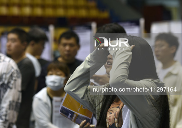 Job seekers are looking for a suitable position at a job fair held by industrial reform enterprises in Huai'an, China, on June 2, 2024. 