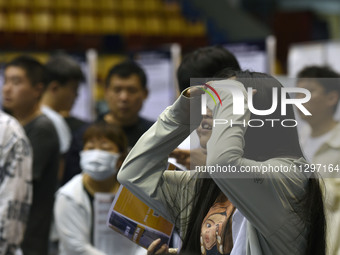 Job seekers are looking for a suitable position at a job fair held by industrial reform enterprises in Huai'an, China, on June 2, 2024. (