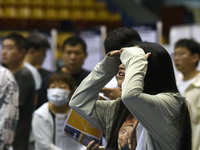 Job seekers are looking for a suitable position at a job fair held by industrial reform enterprises in Huai'an, China, on June 2, 2024. (