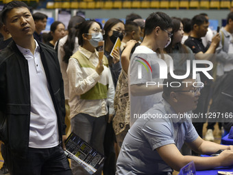 Job seekers are looking for a suitable position at a job fair held by industrial reform enterprises in Huai'an, China, on June 2, 2024. (