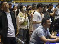 Job seekers are looking for a suitable position at a job fair held by industrial reform enterprises in Huai'an, China, on June 2, 2024. (