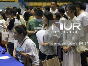 Job seekers are looking for a suitable position at a job fair held by industrial reform enterprises in Huai'an, China, on June 2, 2024. (