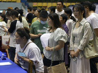 Job seekers are looking for a suitable position at a job fair held by industrial reform enterprises in Huai'an, China, on June 2, 2024. (