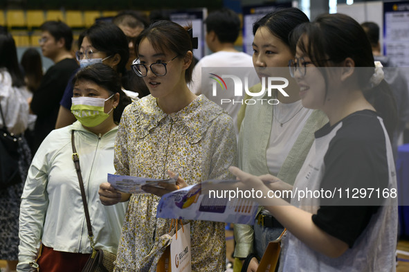 Job seekers are looking for a suitable position at a job fair held by industrial reform enterprises in Huai'an, China, on June 2, 2024. 