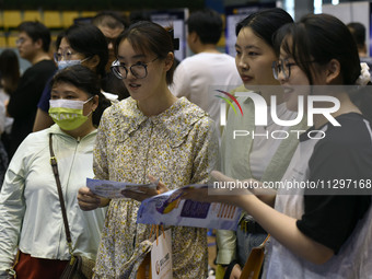 Job seekers are looking for a suitable position at a job fair held by industrial reform enterprises in Huai'an, China, on June 2, 2024. (